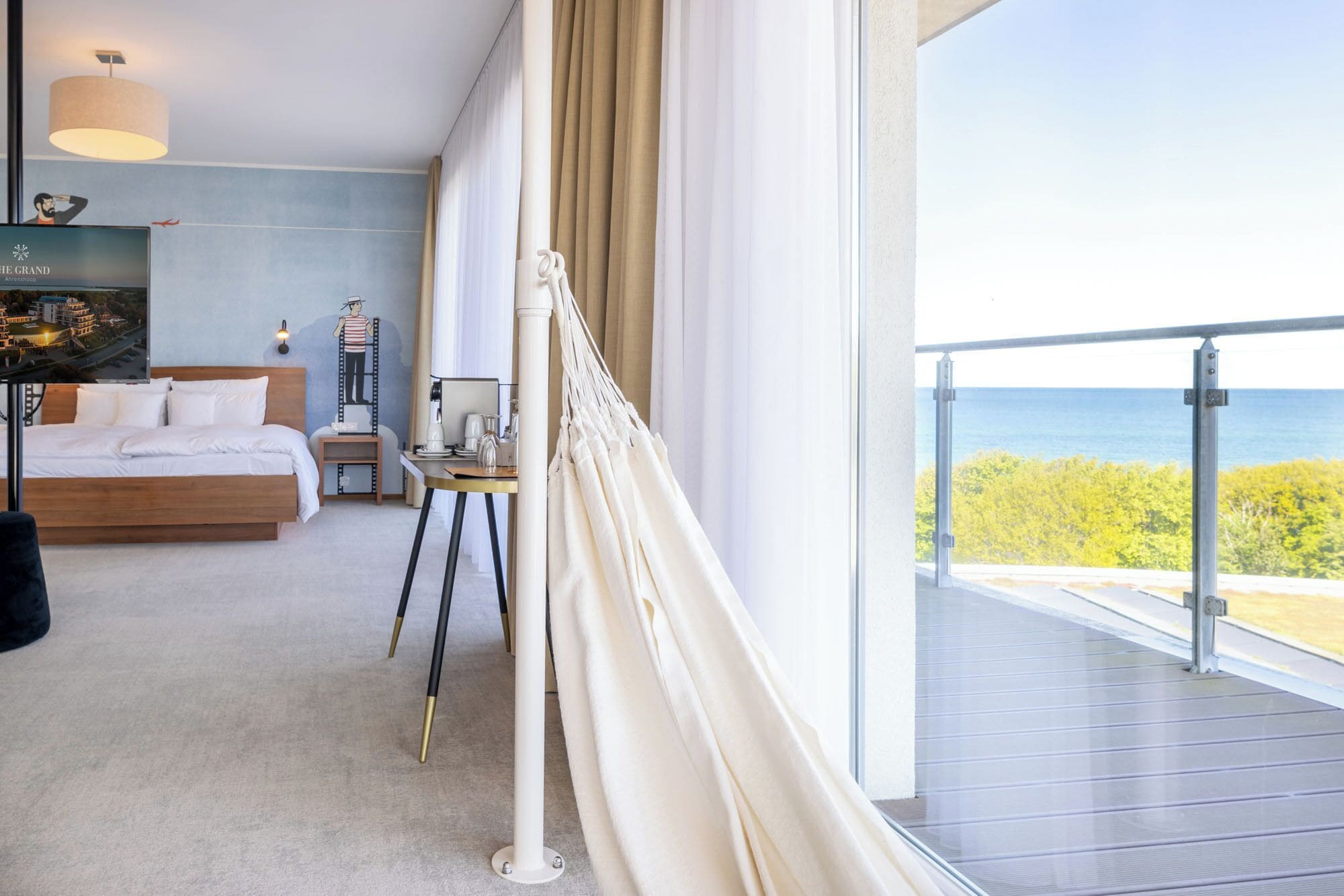 Una camera da letto con un letto, comodino, lampada e vista sul mare.