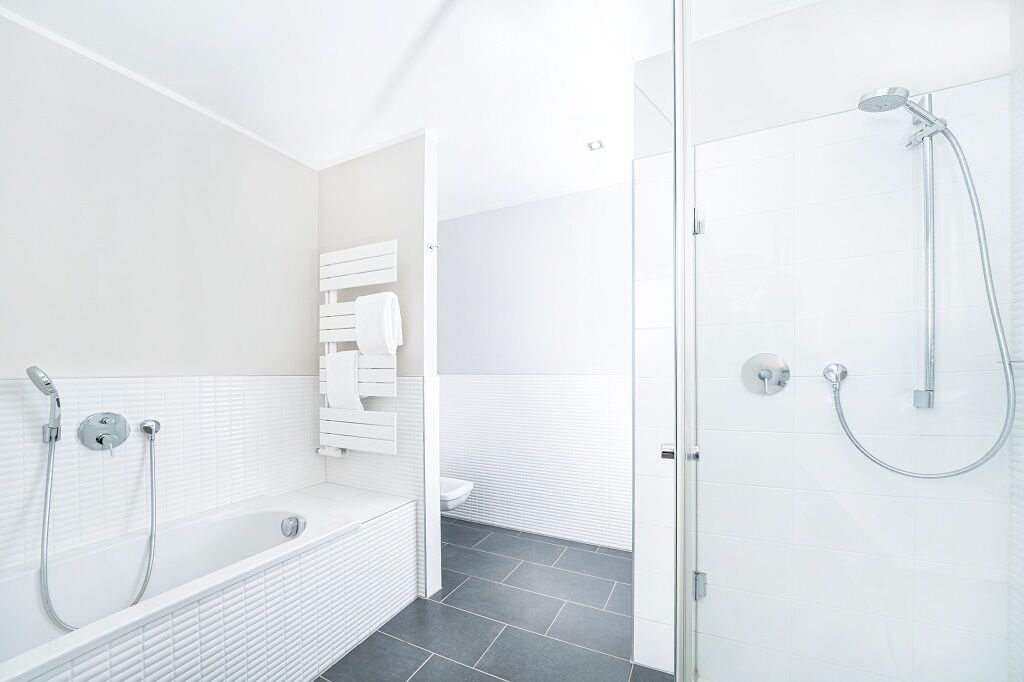 A modern bathroom with a bathtub, a shower, and a toilet.