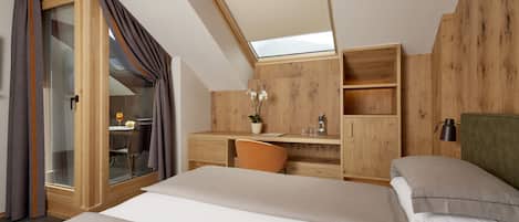 Um quarto com claraboia, paredes de madeira, uma escrivaninha e uma cama.