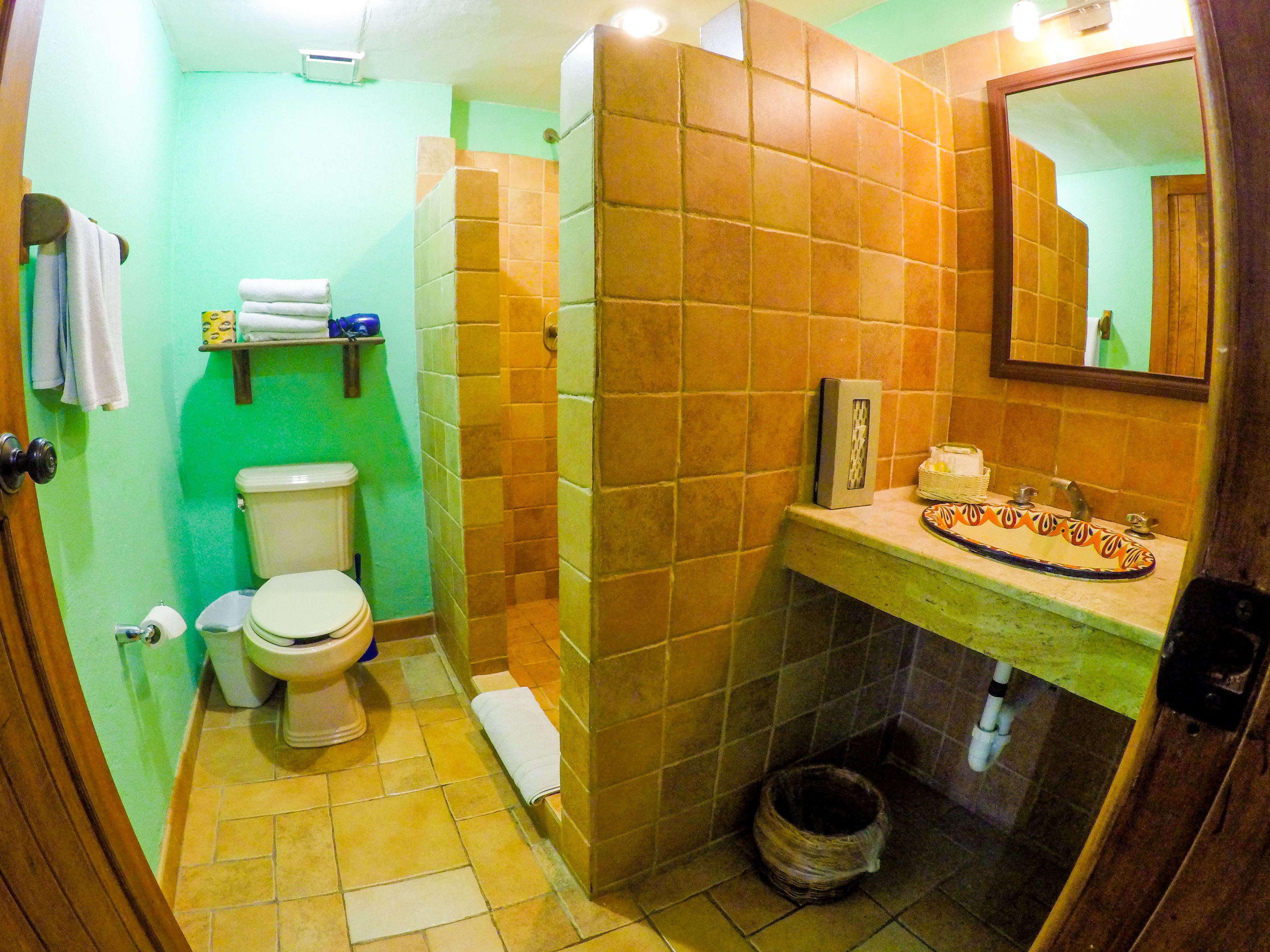 A compact bathroom with a toilet, sink, and shower area.