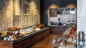 A buffet area with a variety of food items and a sign indicating breakfast options.