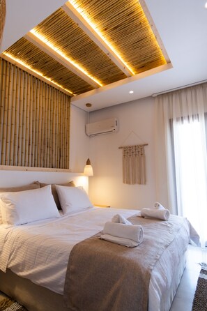 Quarto de hotel moderno com uma cama grande, design de teto em madeira, ar condicionado e janela com cortinas.