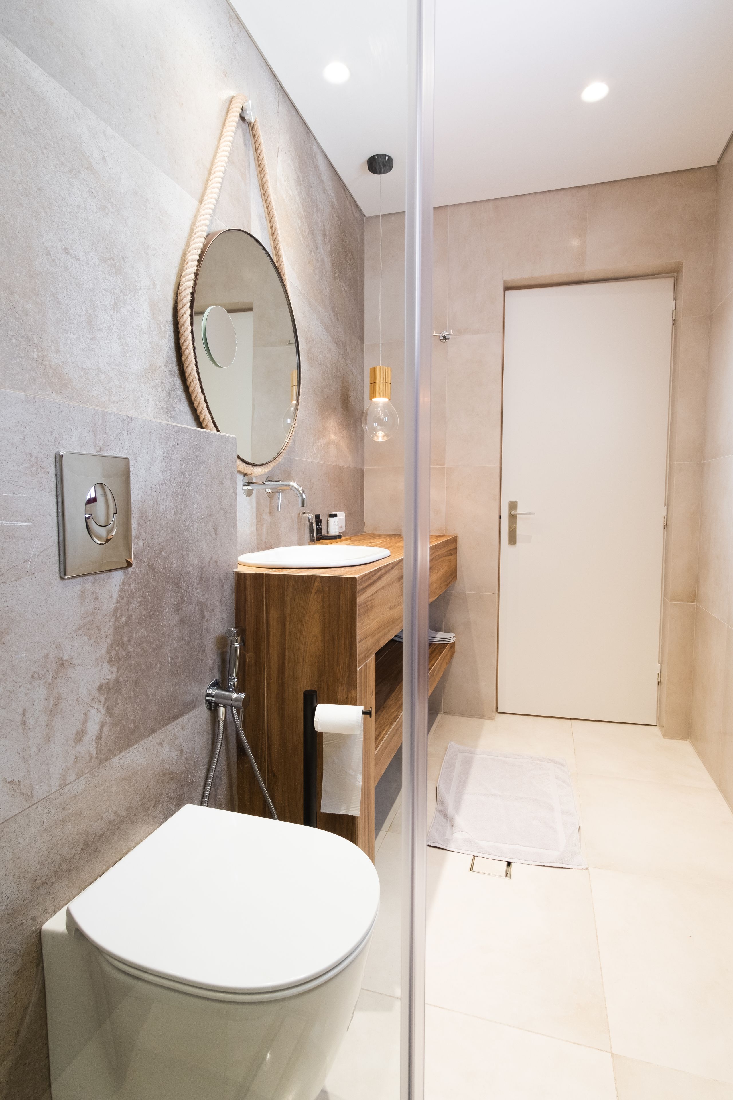 A modern bathroom with a freestanding bathtub, a wooden vanity, a large mirror, and a glass shower enclosure.