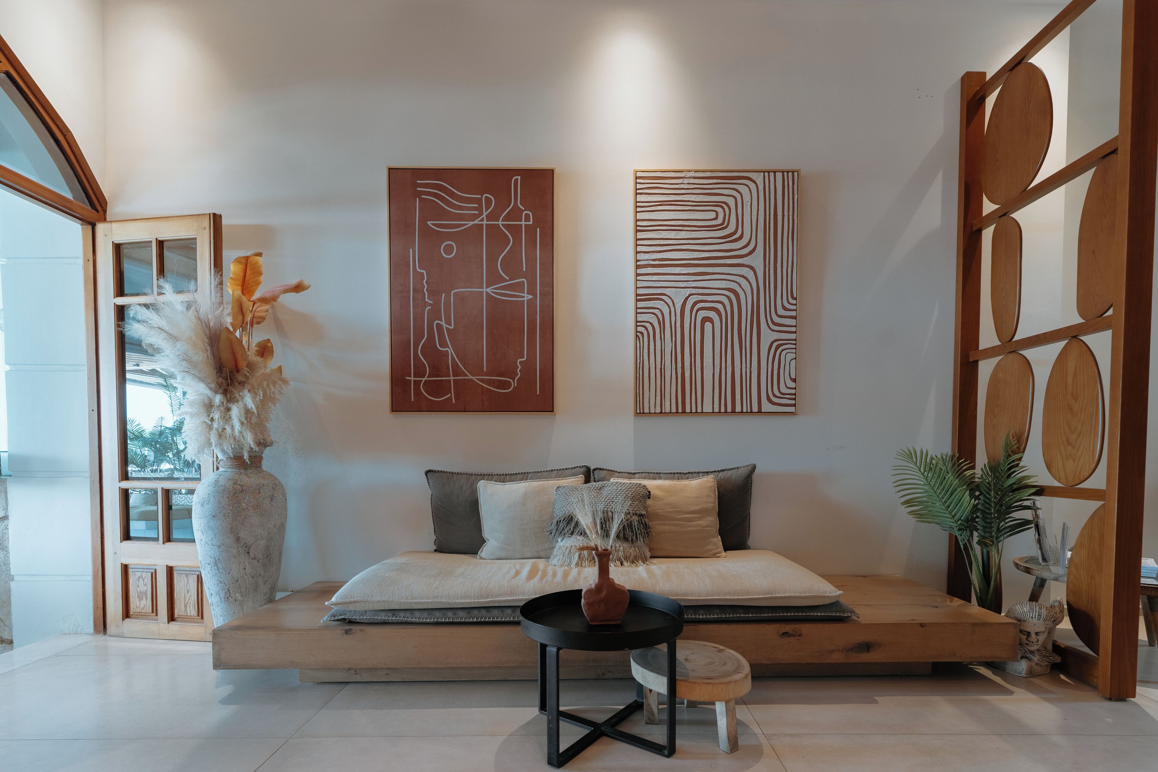 A modern living room with a sofa, a coffee table, and decorative art pieces on the wall.