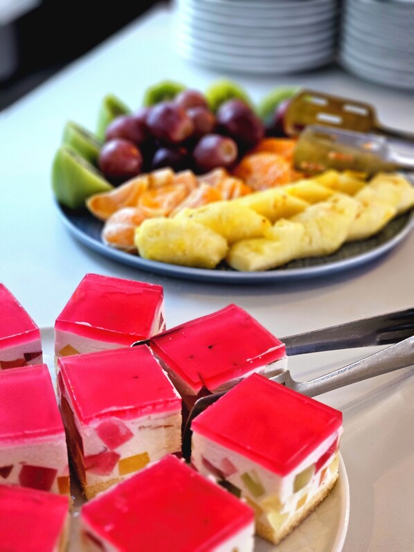 Un plato de comida con diversas frutas y un postre.