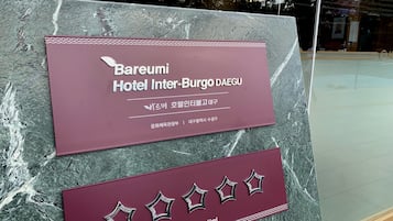 Señal del Hotel Bareumi Inter-Burgo DAEGU con fondo de mármol.