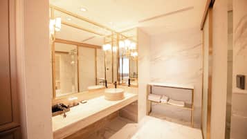 A modern bathroom with a large mirror, a round sink, and a built-in shelf.