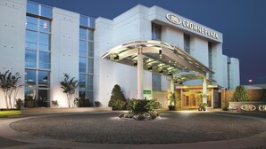 Un hotel moderno con entrada cubierta, ventanas amplias y fachada bien iluminada.