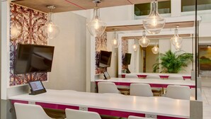 Un área de recepción moderna con un mostrador blanco, diversas opciones de asiento y paneles decorativos en la pared.