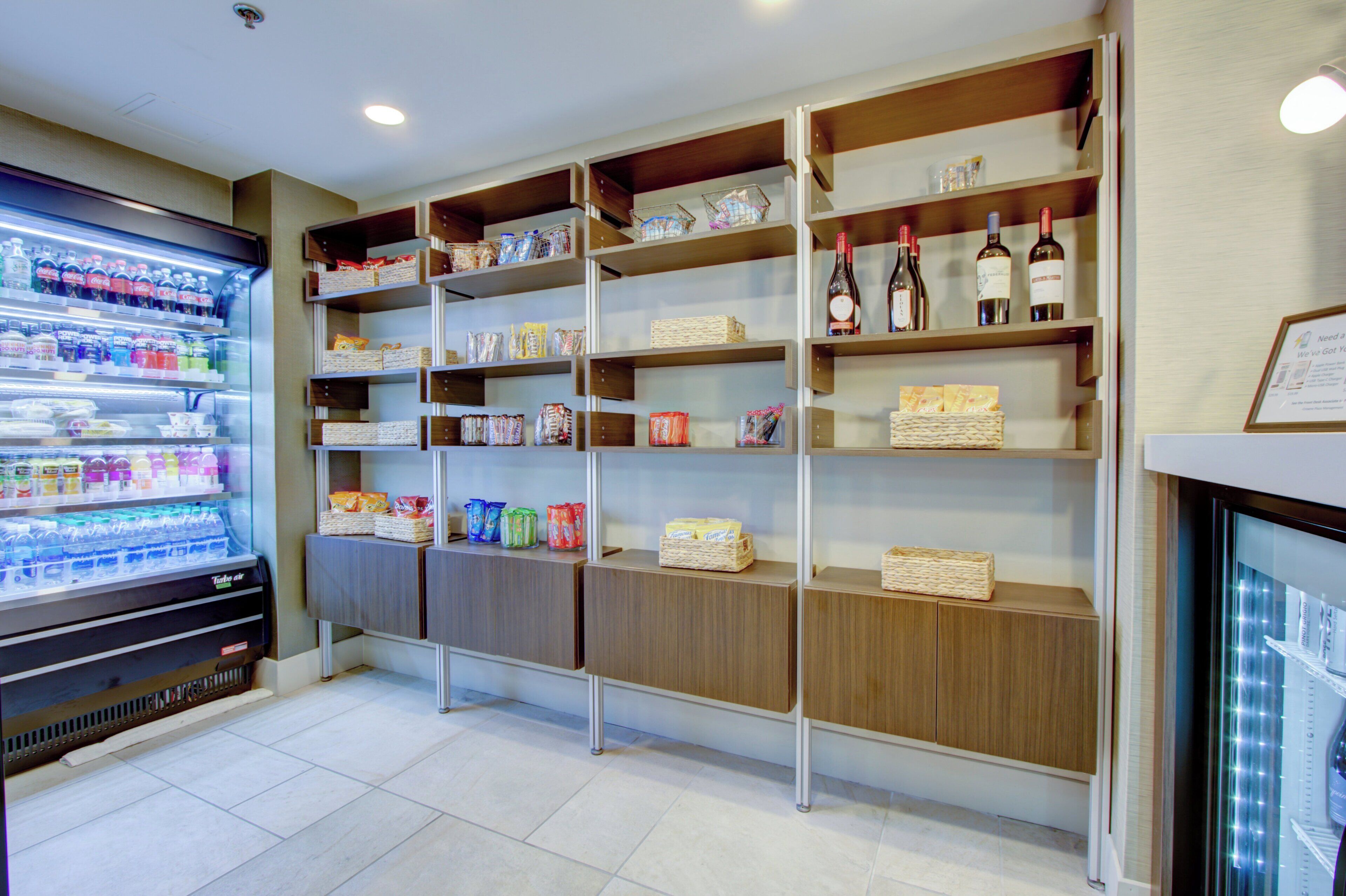 A beverage vending machine and shelves stocked with snacks and bottled water.