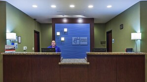 Mostrador de recepción de Holiday Inn Express con una pared azul y una recepcionista.