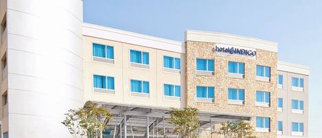 A hotel with a modern design, featuring a stone facade and multiple windows.