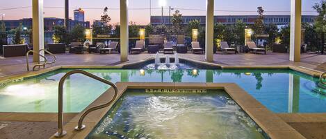 Una piscina al aire libre, tumbonas