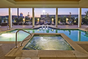 Una piscina al aire libre, sillones reclinables de piscina