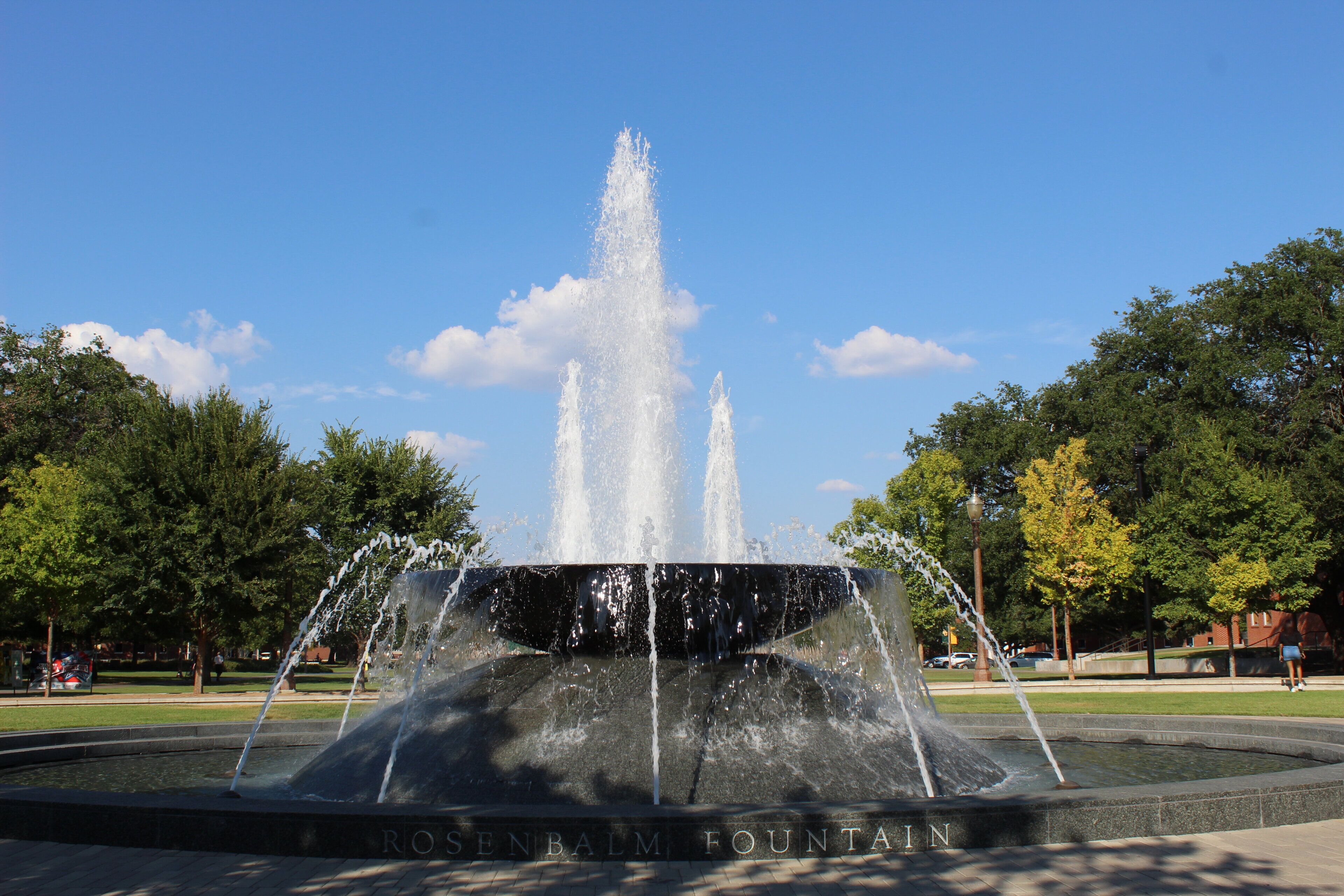 A fountain with water jets in a park setting.