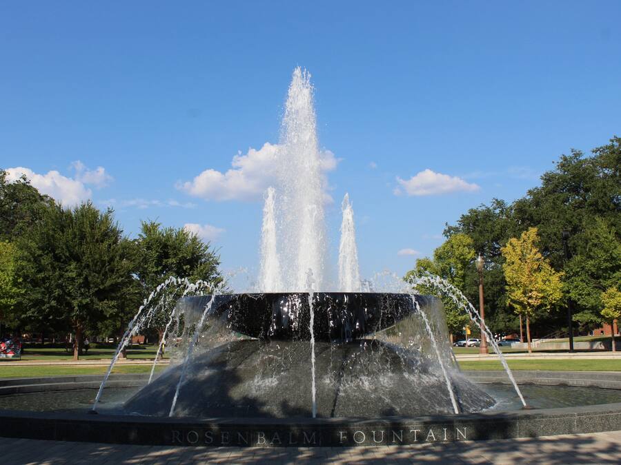 A fountain with water jets in a park setting.