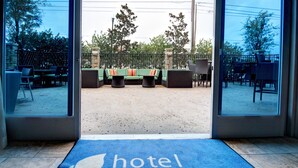 Entrada de un hotel con un felpudo azul que dice 'hotel INDIGO'.