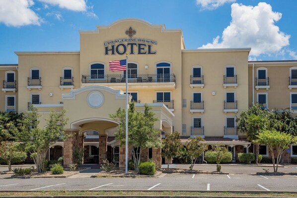 Un hotel con un letrero llamativo, varios balcones y una bandera.