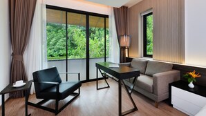 A modern room with a large window, a sofa, a desk, and a lamp. - Tinidee Golf Resort Phuket (Kathu)