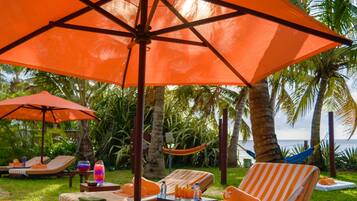 Un resort tropical con sillones de descanso y sombrillas naranjas.