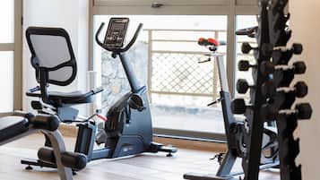 A gym with exercise equipment including a stationary bike, a treadmill, and weight machines.