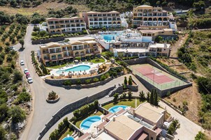 Una piscina techada, sombrillas, sillones reclinables de piscina