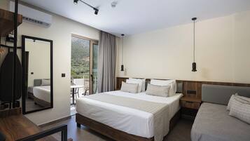 A hotel room with a bed, a desk, a chair, a mirror, and a view of the outdoors.