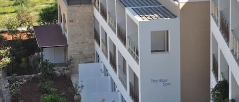 Un hôtel à plusieurs étages au design moderne, doté de balcons et d’un spa appelé « The Blue Spa ».