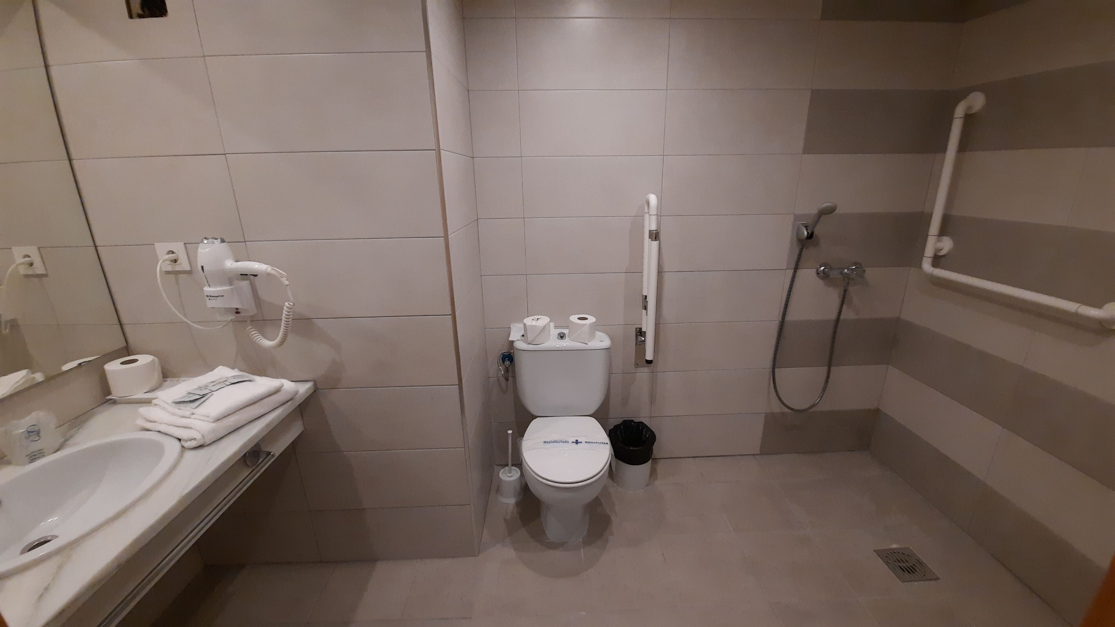 A modern bathroom with a toilet, sink, and shower.