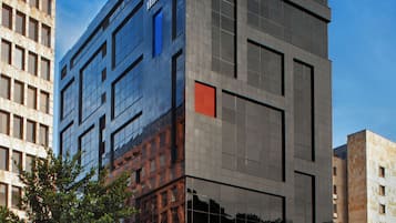 Un moderno edificio de hotel Hilton con fachada de vidrio, varios pisos y un logotipo destacado.