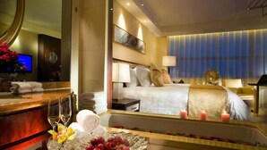 Een hotelkamer met een bed, nachtkastje, lamp en een grote spiegel.