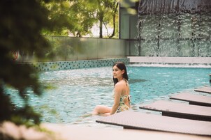 Una piscina al aire libre, sillones reclinables de piscina