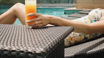 Una piscina al aire libre, sillones reclinables de piscina