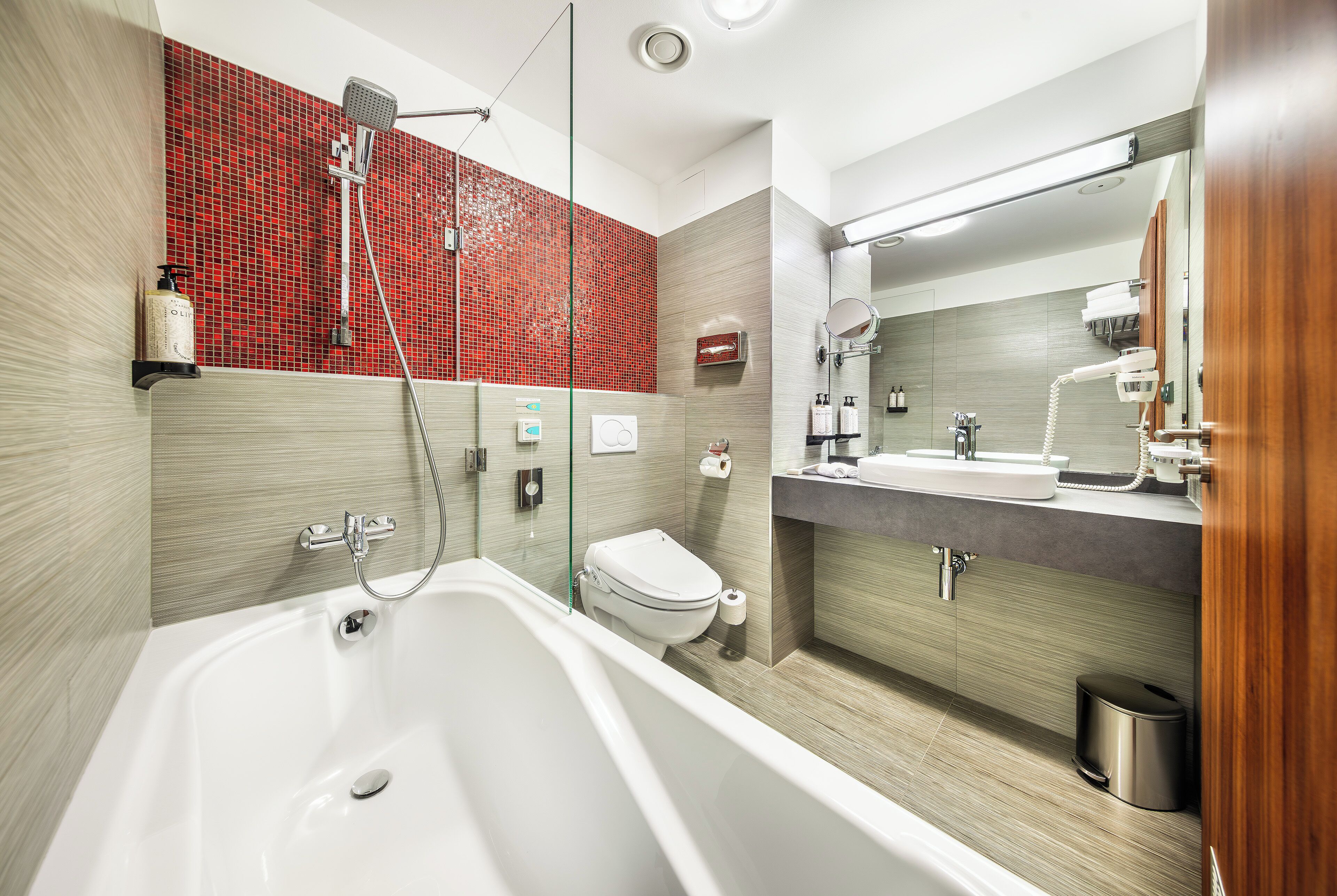 A modern bathroom with a bathtub, a toilet, and a shower area.