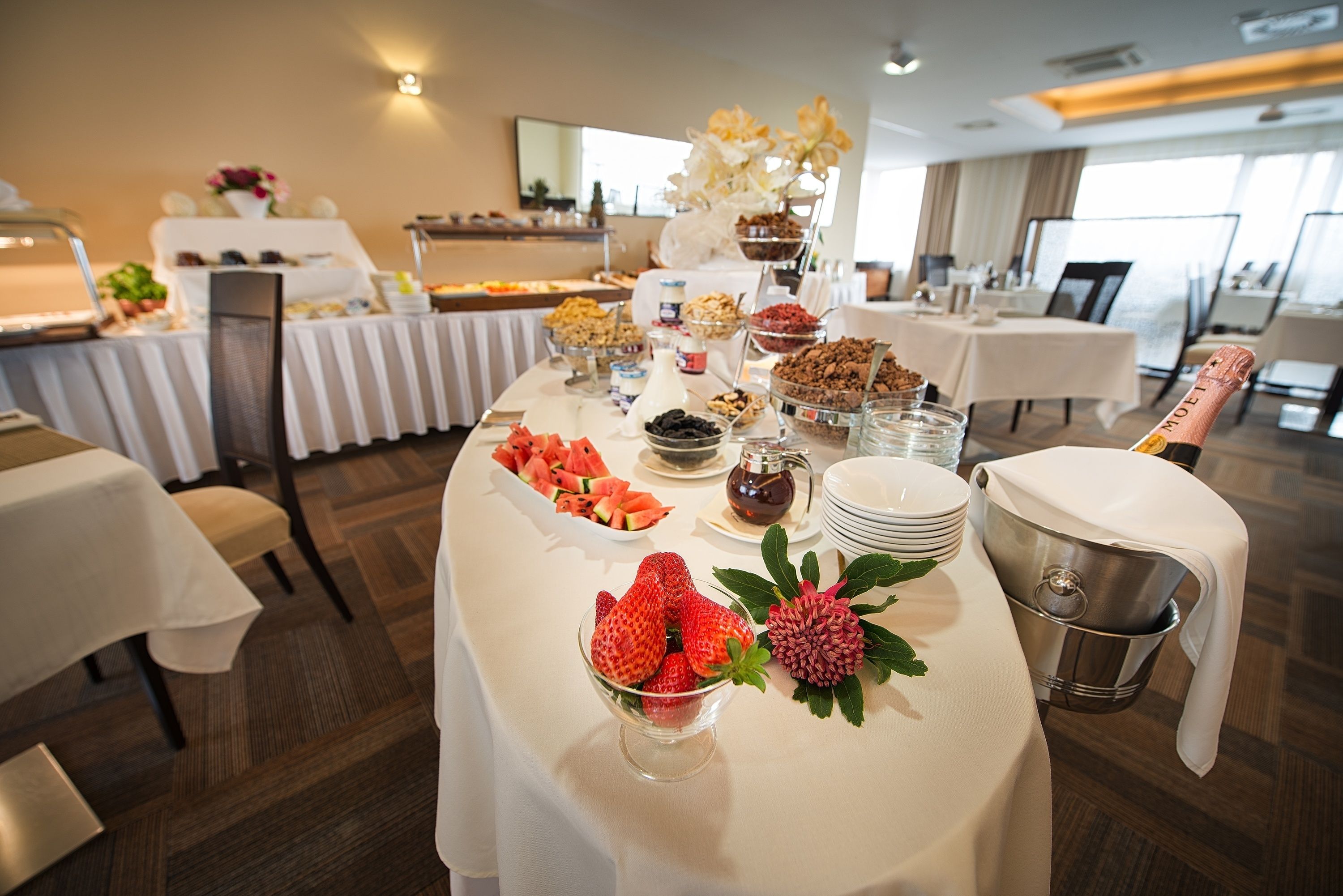 Une table de buffet garnie de divers plats et une bouteille de champagne.