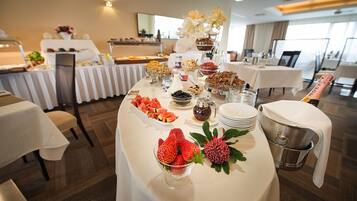 A buffet table with various food items and a champagne bottle.