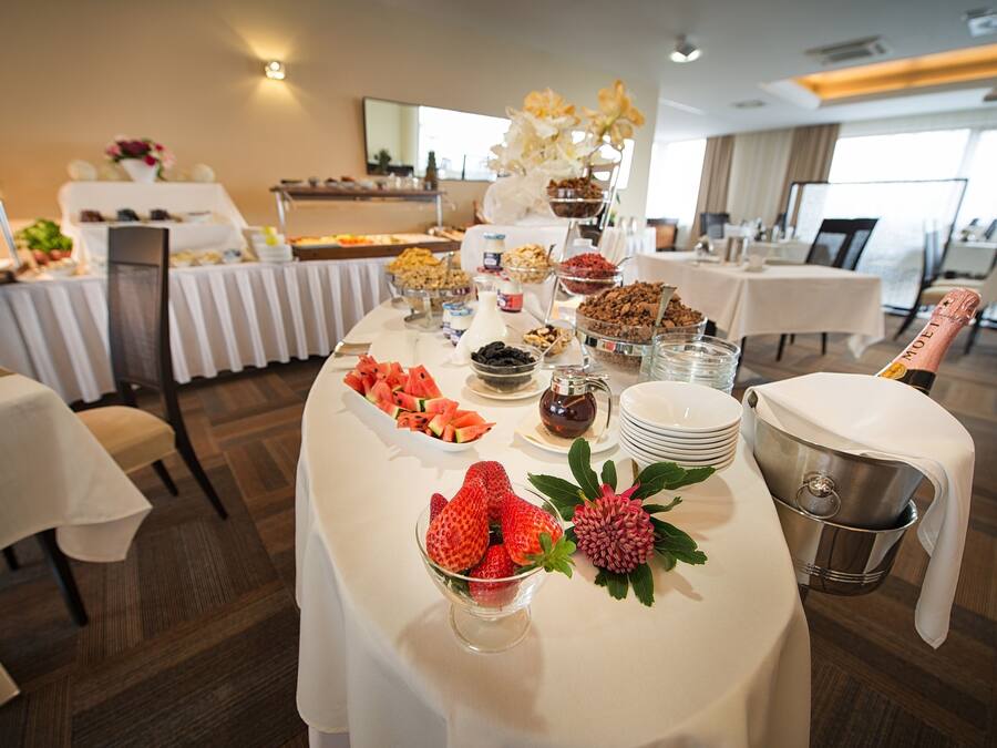 A buffet table with various food items and a champagne bottle.