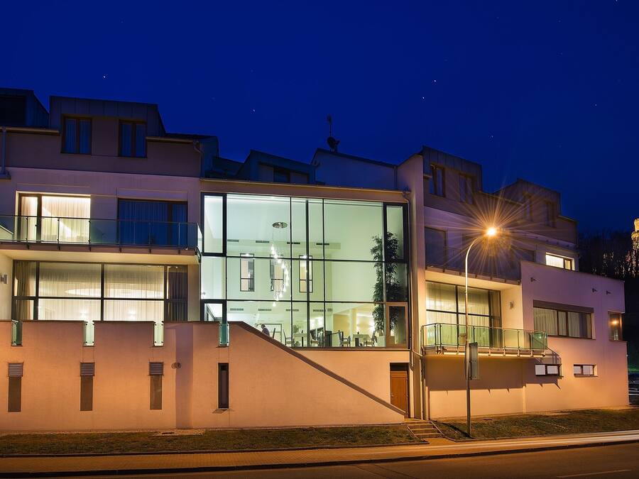A modern building with large windows, a staircase, and a well-lit entrance.
