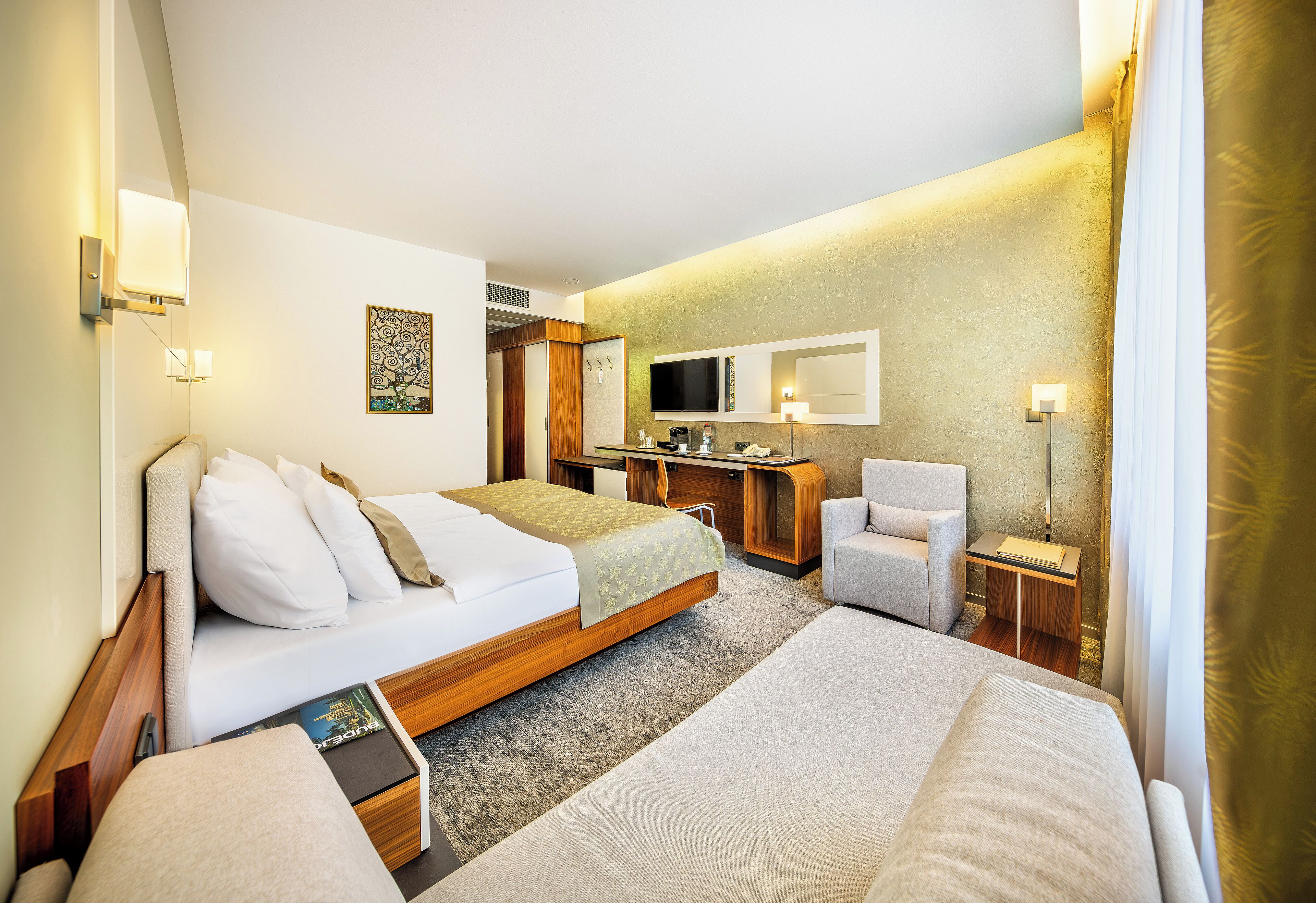 Habitación de hotel con dos camas, un escritorio, una silla, un televisor y un espejo.