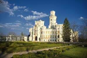 A large, historic building with multiple towers and arched windows, surrounded by well-manicured gardens and pathways. - Wellness Hotel Diamant (Hluboka nad Vltavou)