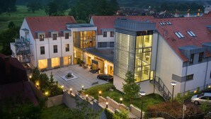 A modern residential building with multiple levels, large windows, and a rooftop terrace. - Wellness Hotel Diamant (Hluboka nad Vltavou)