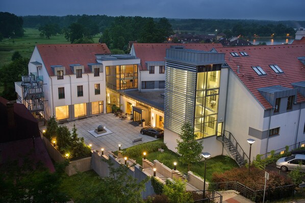 A modern residential building with multiple levels, large windows, and a rooftop terrace. - Wellness Hotel Diamant (Hluboka nad Vltavou)