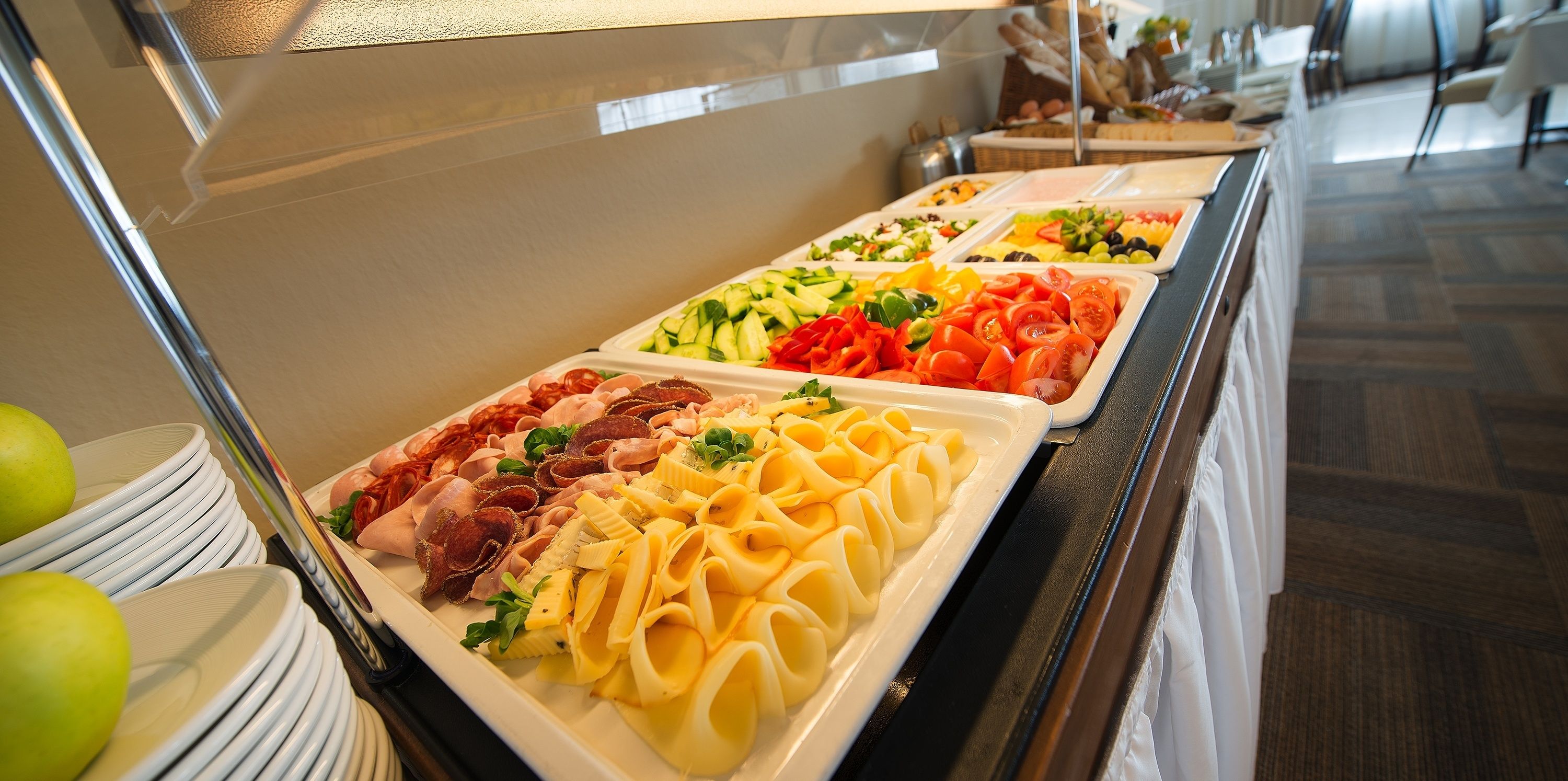 A buffet with various food options including pasta, salads, and meats.