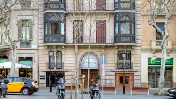 Un edificio de varios pisos con balcones y escaparates.