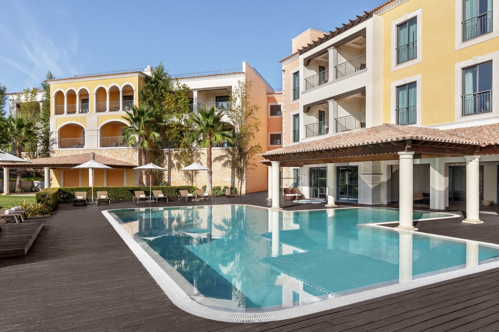 Un hôtel doté d’une piscine, d’un espace extérieur aménagé et de plusieurs balcons.
