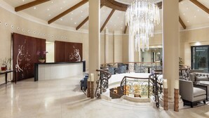 A spacious lobby with a high ceiling, wooden beams, a grand chandelier, and a reception desk. - Cascade Wellness Resort Lagos Algarve by Domes (Lagos)