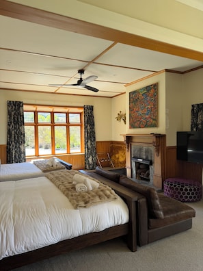 A hotel room with two beds, a fireplace, a television, and a large window with curtains. - Resort Arrowtown (Speargrass Flat)