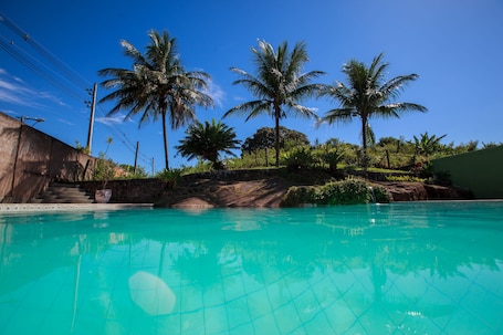 Una piscina al aire libre, sillones reclinables de piscina