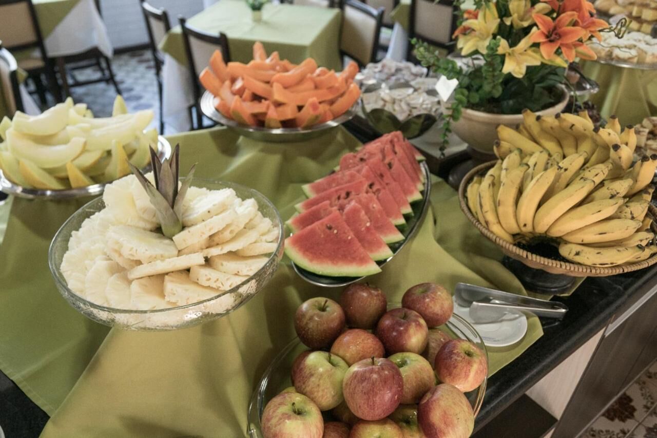 Una mesa de buffet con diversas frutas y verduras, incluyendo manzanas, sandía y plátanos.