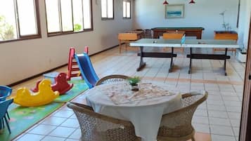Relax in this spacious area with a high ceiling, featuring a pool table and dining space, plus a children's play area.